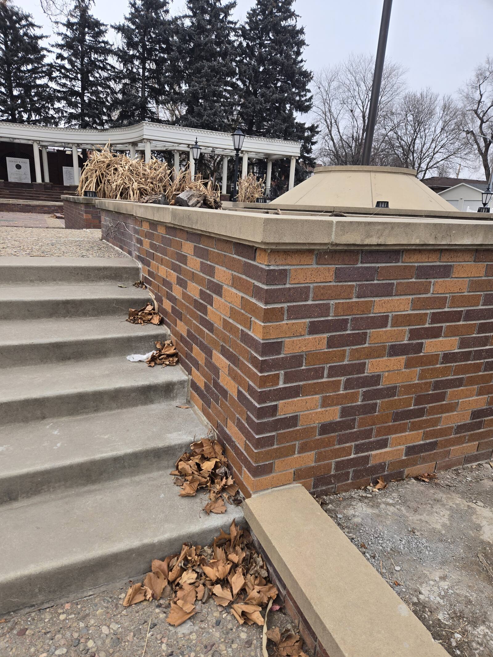 Rebuilt brick retaining wall with concrete cap beside steps