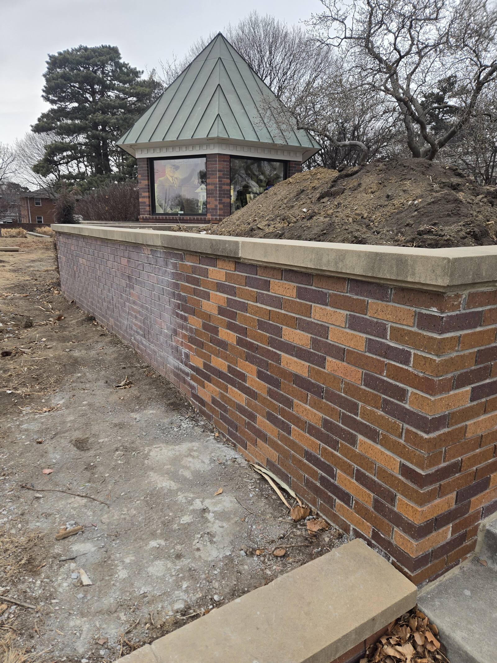 New brick retaining wall holding a landscaped grade